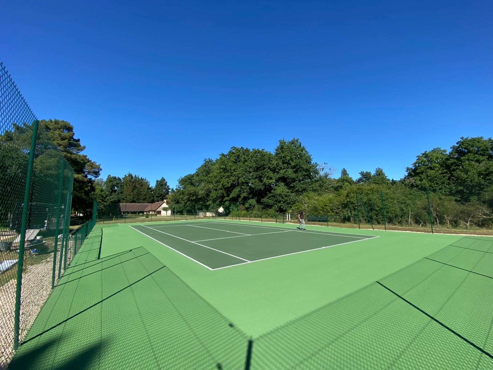Court de tennis en béton poreux avec une zone centrale vert foncé et une bordure extérieure vert clair.